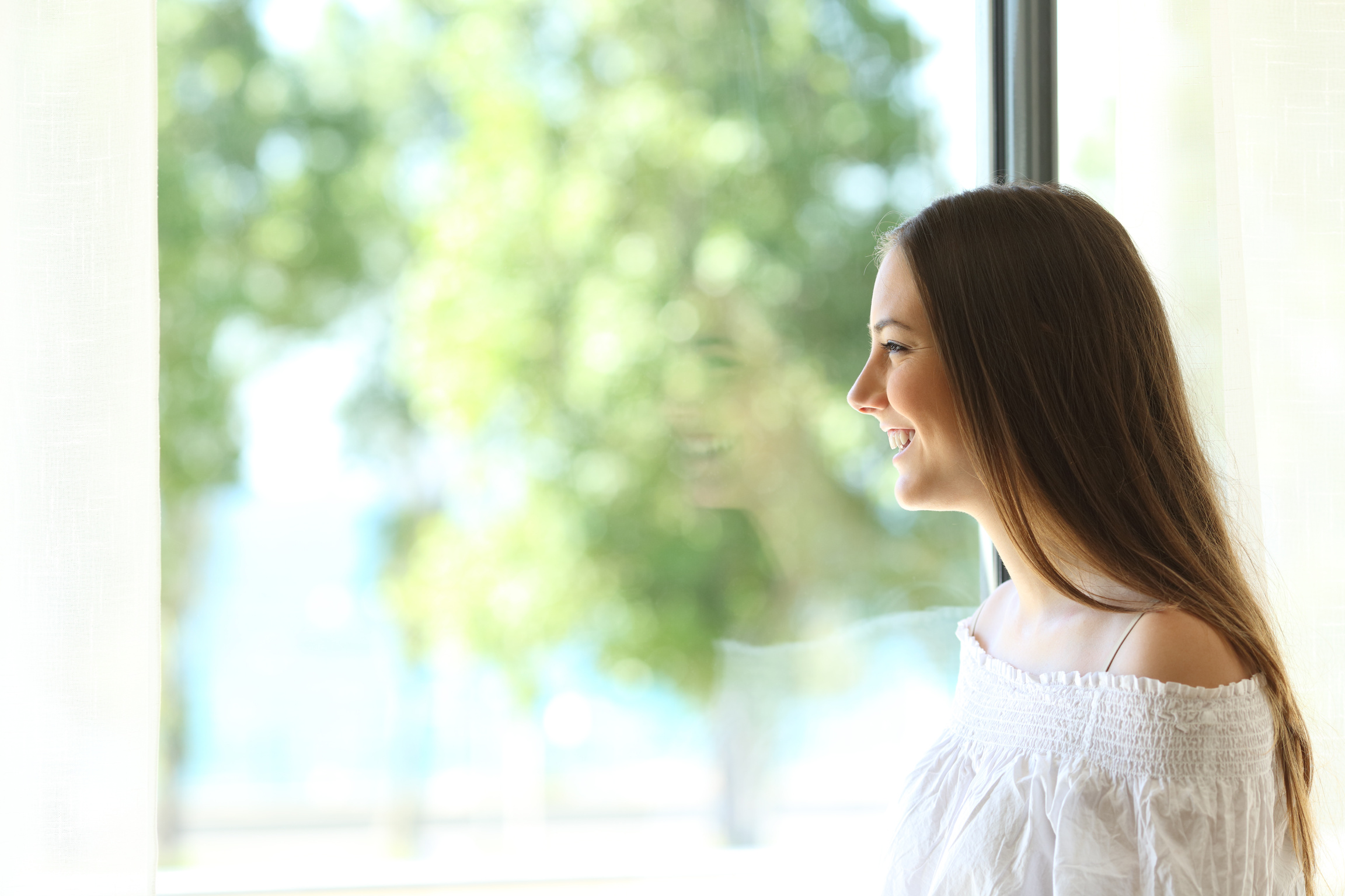 Happy lady looking through a window